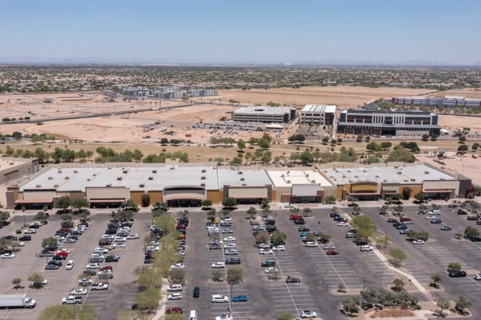 Aerial view of sprawling commercial development with parts still under construction and parking lot in Goodyear, Arizona